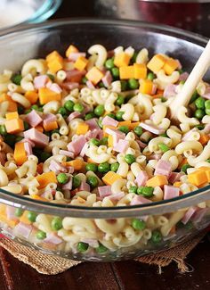 a glass bowl filled with pasta and peas