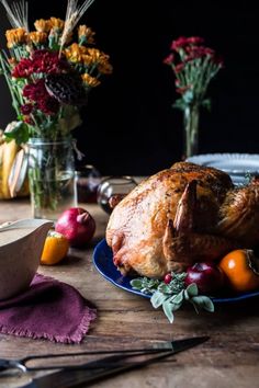 a roasted turkey on a blue plate surrounded by flowers and other thanksgiving decorating items