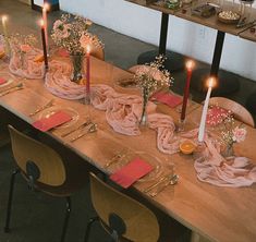 a long table with candles and napkins on it