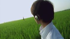 a person wearing headphones standing in a field