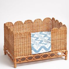 a wicker baby crib with a blue and white blanket on it's side