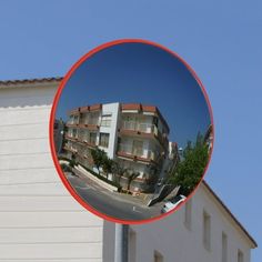 the reflection of an apartment building in a round mirror