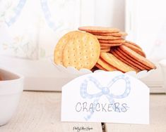 crackers are sitting on a table next to a bowl of carrots and a sign that says crackers