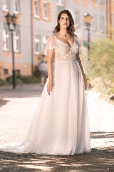 a woman in a white dress standing on the street