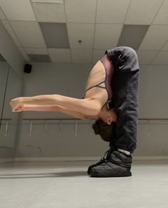 a person doing a handstand in an empty room