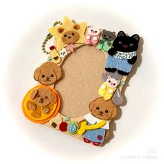 a frame made out of felt with teddy bears and other items around it on a white surface