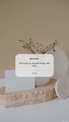 a white vase filled with flowers sitting on top of a wooden table next to an email box