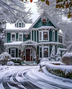 a large green house with wreaths on it's windows and trees in the snow