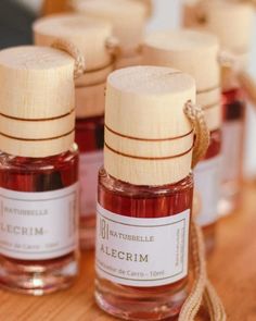 several small bottles filled with red liquid sitting on top of a wooden table