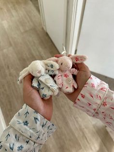 a person holding several small stuffed animals in their hands on the floor next to a door