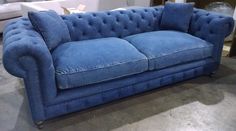 a blue couch sitting on top of a hard wood floor