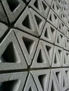 a wall made out of cement blocks with different shapes and sizes on the top half