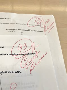 two papers with autographs on them sitting on a wooden table next to each other