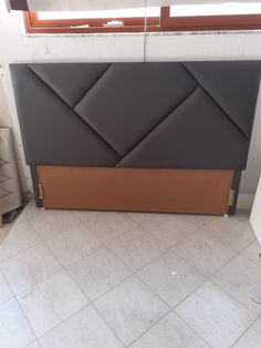 a black and brown headboard sitting on top of a tiled floor