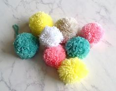 six pom - poms on a marble surface