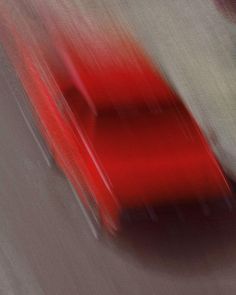 a blurry photo of a red car driving down the road