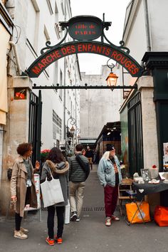 people are walking through an open market area