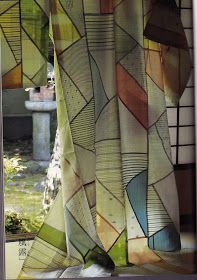 an open window with colorful curtains in front of it and a potted plant on the other side