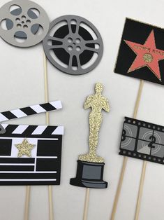 some cupcake toppers are on sticks with film reels and clapsticks