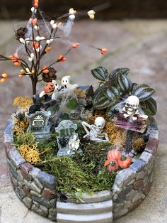 a miniature garden with skeletons and pumpkins