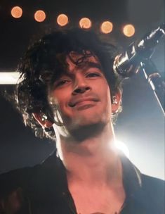 a man with curly hair holding a microphone