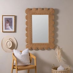 a chair and mirror in a room with pictures on the wall above it, along with a hat