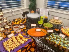 a table filled with halloween treats and desserts