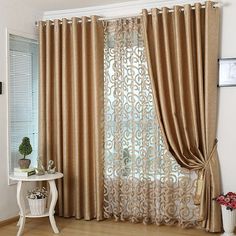 the curtains in this living room are gold and brown, with an intricate design on them