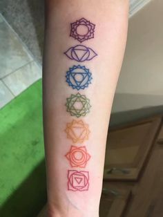 a woman's arm with seven chakras on it