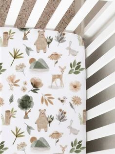 a crib sheet with animals and plants on it in a nursery bedding set