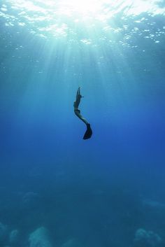 a person is swimming in the ocean with their feet up and arms out to the side