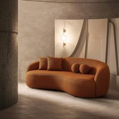 an orange couch sitting in a room next to a round light fixture on the wall