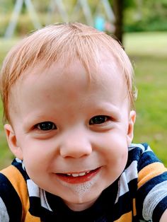 a little boy that is smiling for the camera