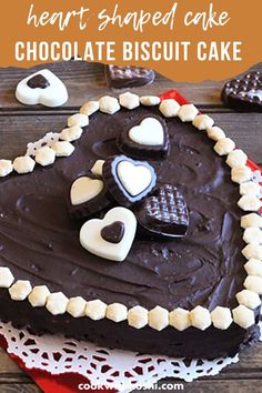 a heart shaped cake with chocolate frosting and hearts