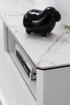 a black object sitting on top of a white cabinet