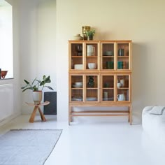 a living room with a white couch and wooden shelves filled with dishes on top of them