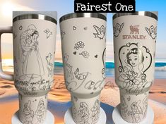 three disney princess travel mugs on the beach