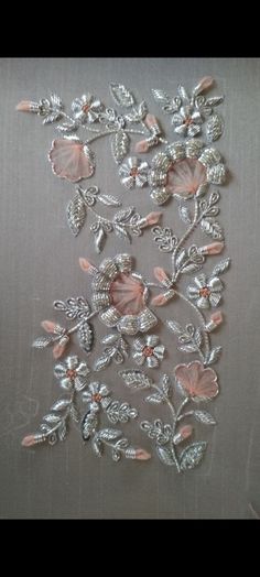 some pink flowers and leaves on a silver surface