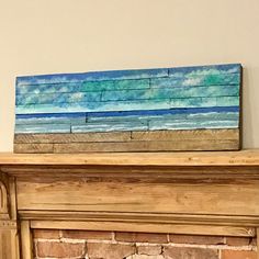 a painted wooden block sitting on top of a fireplace mantle next to a fire place