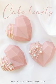 three pink heart shaped cakes with pearls on them