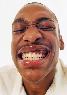 a close up of a person with his eyes closed and mouth wide open, smiling