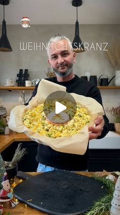 a man holding a pizza in his hands with the words weihnach fiskranzo on it