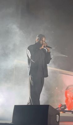 a man standing on top of a stage holding a microphone in front of his face