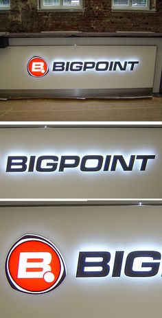 three bigpoint signs are lit up in front of a brick building