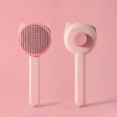 two pink hair brushes on a pink background