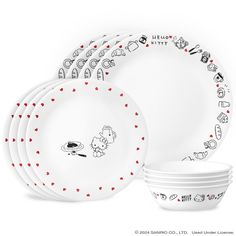 a set of white dinnerware with red polka dots on the rims and plates