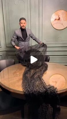 a man is sitting at a table with an animal print scarf around his neck and legs