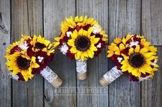 three bouquets of sunflowers are arranged on a wooden surface