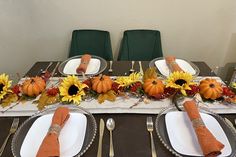 the table is set with sunflowers and pumpkins