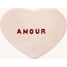 a heart shaped pillow with the word amour written in red on it's side